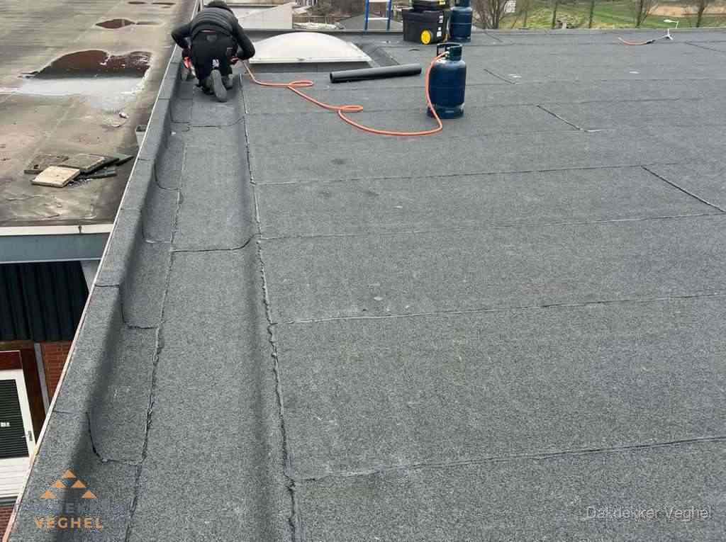 Dakdekker repareert bitumen dakbedekking op groot plat dak in Veghel Dakdekker repareert bitumen dakbedekking op groot plat dak in Veghel